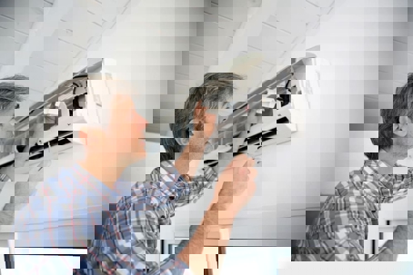 tech checking the AC unit filters