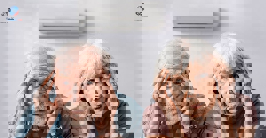 An older couple holds their heads looking confused with an air conditioner above them.