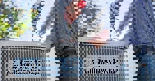 A person uses a power drill to repair an air conditioner.