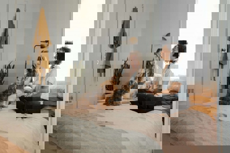 Two women and a dog resting in their bedroom