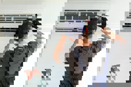 A technician repairs an air conditioner.