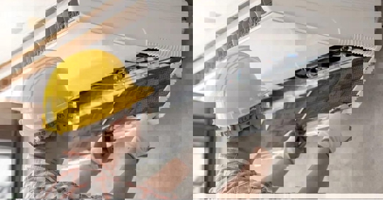 An HVAC technician changes a filter in an AC unit.