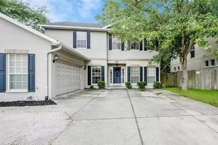 A two-story house with a wide driveway is visible.