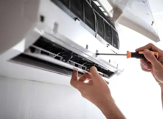 A technician repairing an AC unit