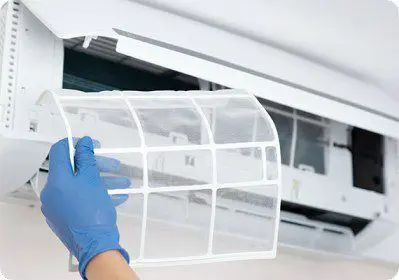 A technician holding an AC filter